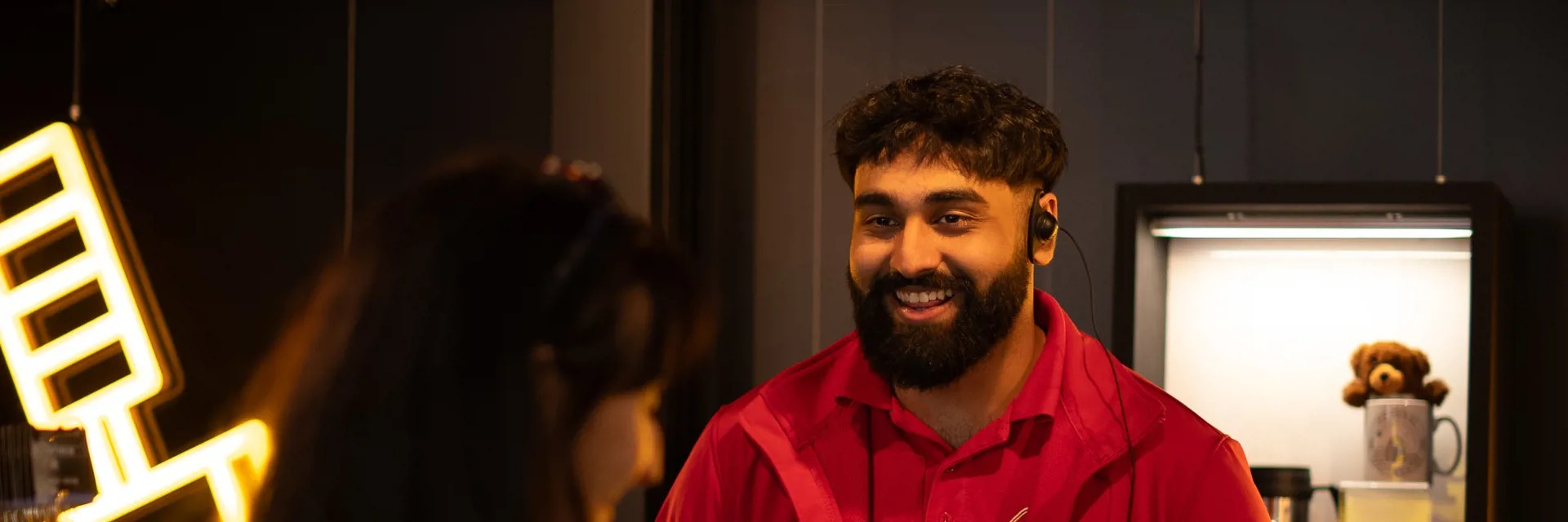 A member of Space Crew is serving a child and their parent in the National Space Centre's gift shop.